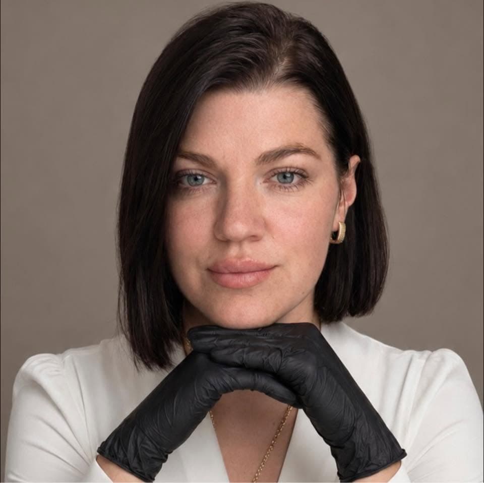 A professional working in aesthetics, photographed in a white top and black gloves